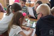 	dzieci przeglądają książki popularno-naukowe	