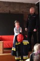 dzieci przymierzają strój strażaka