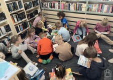 Powiększ zdjęcie Dzieci%20czytają%20książki%20w%20bibliotece