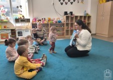 Powiększ zdjęcie Bibliotekarka czyta dzieciom książkę