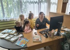 Powiększ zdjęcie Bibliotekarka%20prezentuje%20dzieciom%20ladę%20biblioteczną