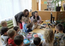 Powiększ zdjęcie Bibliotekarka%20prezentuje%20dzieciom%20ladę%20biblioteczną