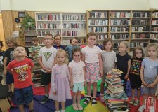Powiększ zdjęcie Dzieci pozują do zdjęcia z wykonanymi książkowymi wieżami