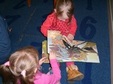 dzieci oglądają książki o dinozaurach